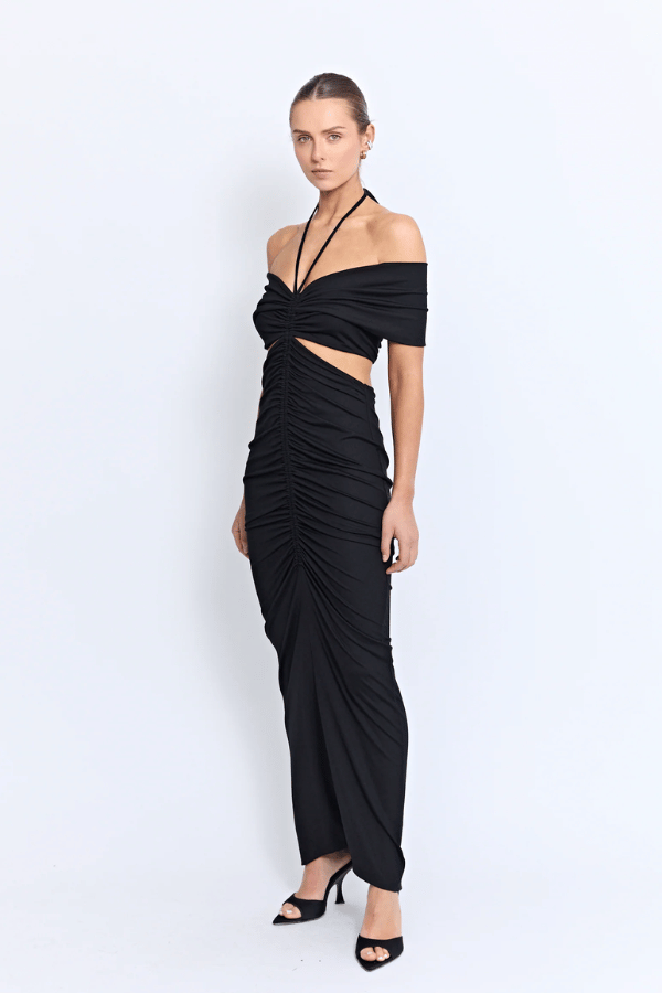 Angello Maxi Dress Black by Pfeiffer – A sleek off-shoulder maxi with cut-outs, front ruching, and an open back, perfect for formal evenings, special events, or statement celebrations.