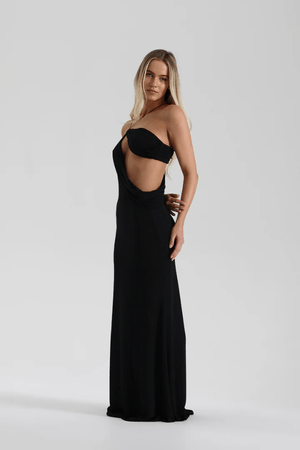 Elissa Dress Black by Natalie Rolt – A glamorous stretch-knit maxi with metallic threads, asymmetrical cutaway, and adjustable fit, perfect for elegant evenings and special occasions.