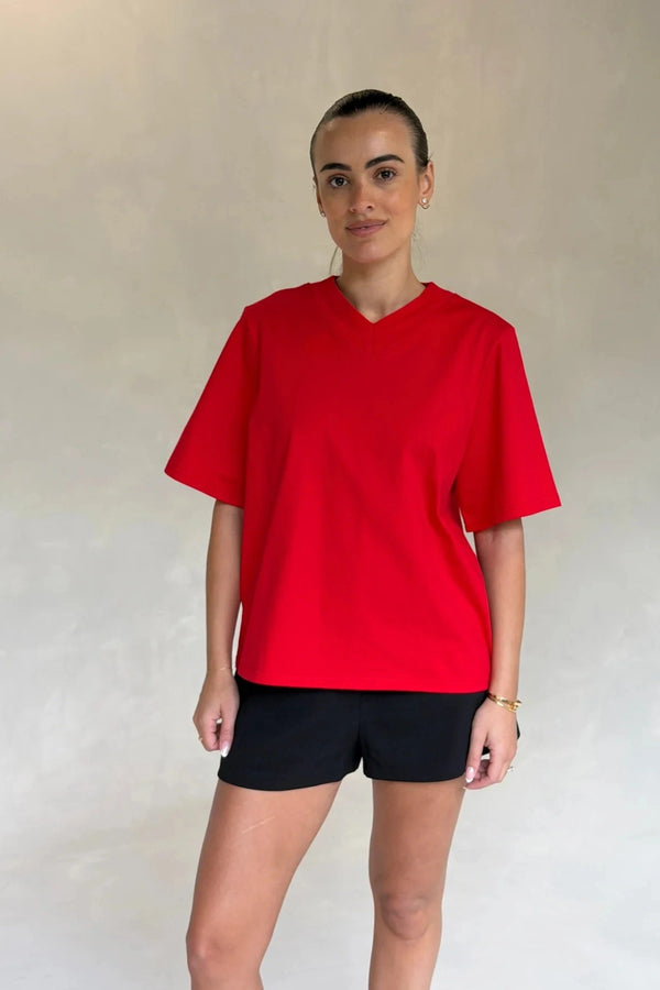 Red Olivia High V Neck Relaxed Tee with short sleeves and a loose fit on a plain background.