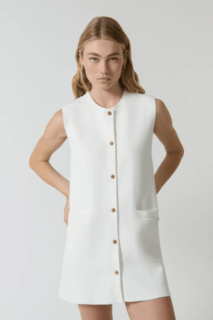 Nanda Dress White by Onte – A chic, timeless sleeveless mini shift in heavy Milano knit with gold knot buttons and welt pockets, perfect for effortless day-to-night style.