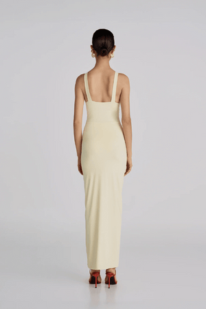 Alquimia Maxi Dress Vanilla by Maygel Coronel – A sculpting open-back maxi with ruched front and bold handmade floral detail.