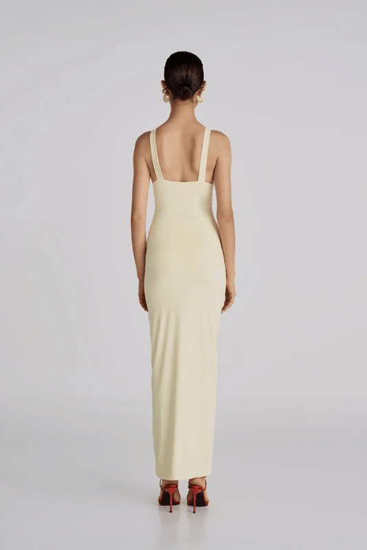 Alquimia Maxi Dress Vanilla by Maygel Coronel – A sculpting open-back maxi with ruched front and bold handmade floral detail.
