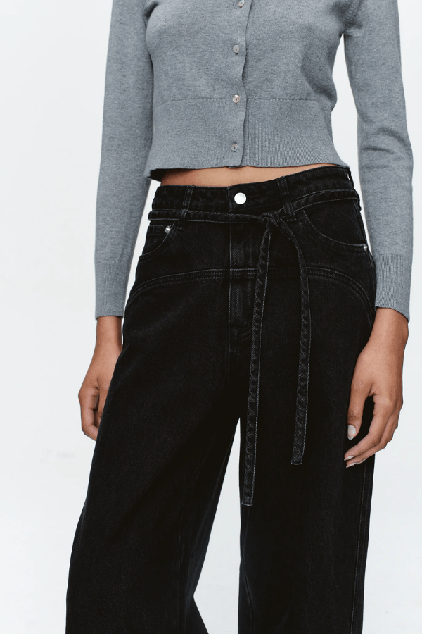 Tie Curve Seam Jean Black by Marle, trendy mid-rise jeans with unique curved seam detailing and a relaxed, wide-leg fit. Perfect for a versatile, structured look with a detachable tie belt.