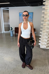 Black mid-rise balloon pants with a relaxed fit and tapered ankles, styled on a model against a plain background.