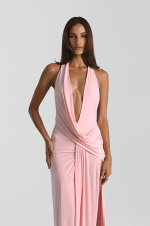 Winona Gown Blossom Pink by Natalie Rolt, elongated halter neckline, asymmetric draped bust overlay, open back, exaggerated side split, gathered waterfall skirt, full-length hem, elevated jersey. Dry clean only.