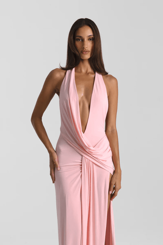 Winona Gown Blossom Pink by Natalie Rolt, elongated halter neckline, asymmetric draped bust overlay, open back, exaggerated side split, gathered waterfall skirt, full-length hem, elevated jersey. Dry clean only.
