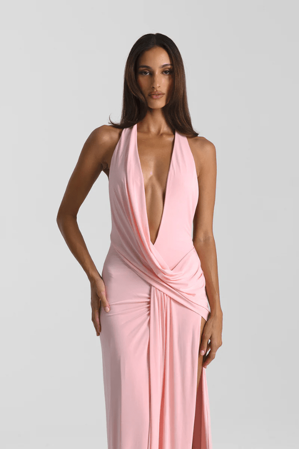 Winona Gown Blossom Pink by Natalie Rolt, elongated halter neckline, asymmetric draped bust overlay, open back, exaggerated side split, gathered waterfall skirt, full-length hem, elevated jersey. Dry clean only.