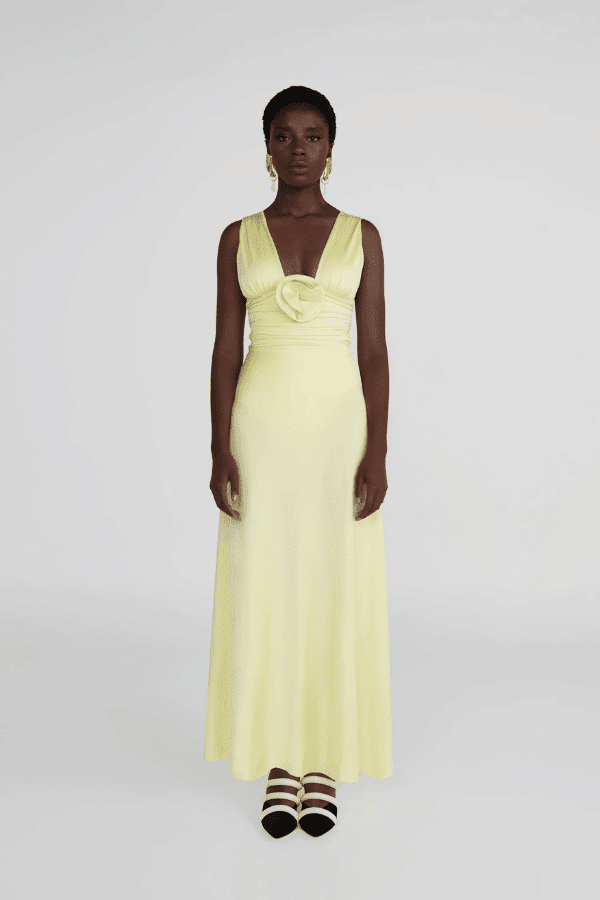 Orinoco Lime by Maygel Coronel – Maxi dress with deep V-neck, ruched bodice, 3D flowers, wide straps, and flowing skirt.