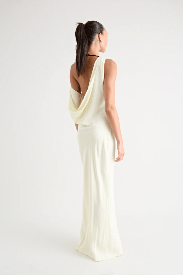 Matia Gown Butter by Pfeiffer – A timeless maxi with a boat neckline, low back, and adjustable strap. Perfect for elegant events and special occasions.