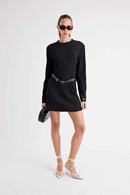 Fairbank Rib Dress Black by Pfeiffer – A trendy, comfortable ribbed bamboo dress with high raw-edge neckline, full sleeves, and versatile two-part back design. Perfect for chic casual wear or layering in cooler seasons.