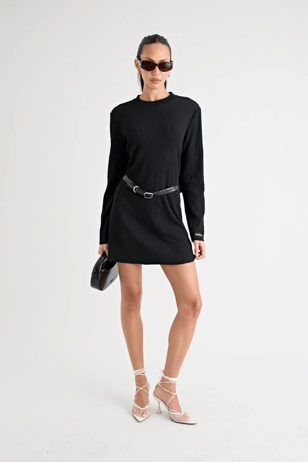 Fairbank Rib Dress Black by Pfeiffer – A trendy, comfortable ribbed bamboo dress with high raw-edge neckline, full sleeves, and versatile two-part back design. Perfect for chic casual wear or layering in cooler seasons.