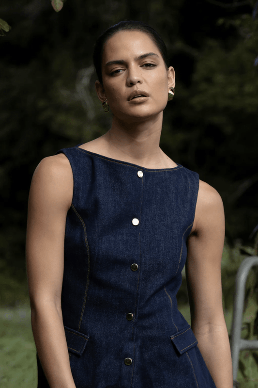 Good Vibes Midi Indigo by Pasduchas – Trendy stretch denim midi with contrast stitching, gold snaps, and tailored pockets, perfect for sleek day-to-night style.