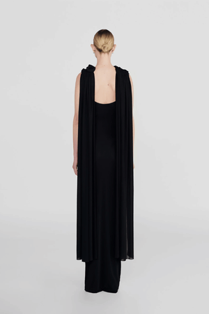 Batista Basalto by Maygel Coronel – An elegant long dress with a cowl scoop neckline, flowing shoulder sashes, and a sleek column silhouette, perfect for sophisticated evening events and making a timeless, statuesque statement.