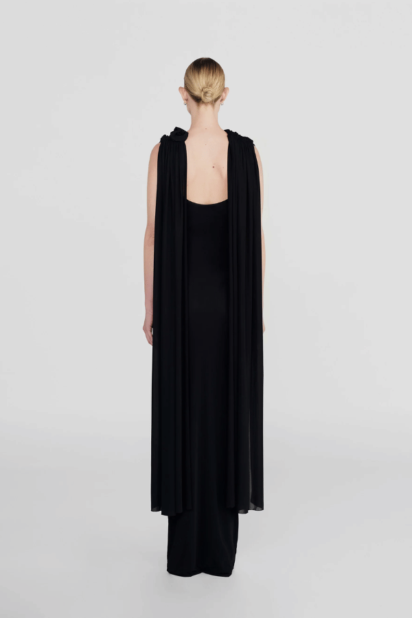 Batista Basalto by Maygel Coronel – An elegant long dress with a cowl scoop neckline, flowing shoulder sashes, and a sleek column silhouette, perfect for sophisticated evening events and making a timeless, statuesque statement.