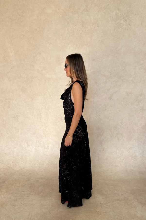 Lucy Lace Maxi Dress in Black by Sneaky Link, a sheer lace gown with draped neckline and elegant silhouette. Perfect for evening occasions.
