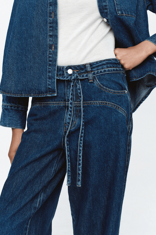 Tie Curve Seam Jean Heritage Blue by Marle, trendy mid-rise jeans with unique curved seam detailing and a relaxed, wide-leg fit. Perfect for a versatile, polished look with a detachable tie belt.