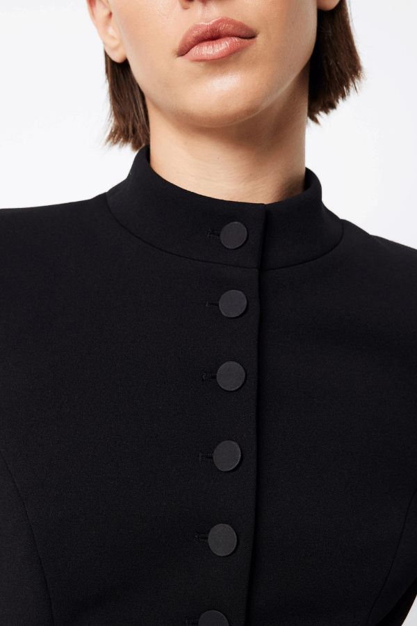 Network Mini Dress Black by Mossman – A sleek, structured LBD with padded shoulders, high neckline, and functional pockets, perfect for day-to-night chic.