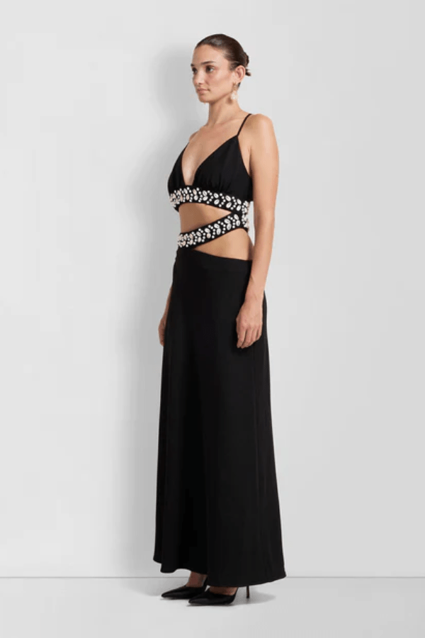La Playa Maxi Dress Noir by The Wolf Gang – Maxi dress with cowrie shell cutouts, adjustable tie, and luxe gold clasp closure.