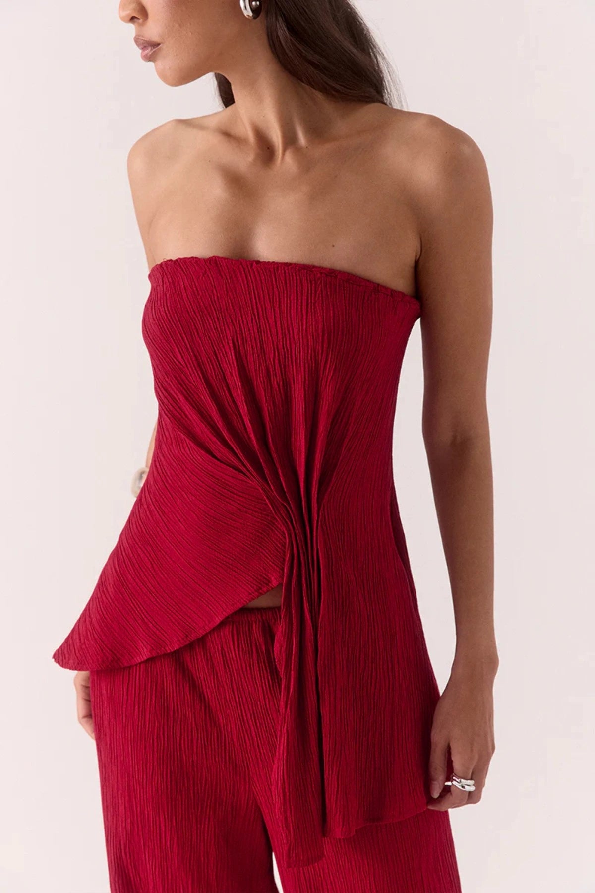 Aine Top in Raspberry by Sovere – strapless crinkle top with pleated waist and asymmetric hem. Perfect for bold, warm-weather looks.