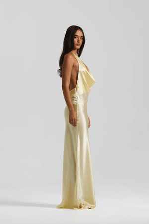 Gabi Gown Lemon by Natalie Rolt – A trendy bias-cut silk gown with an elegant asymmetric silhouette, open back, and delicate ties, perfect for special occasions.