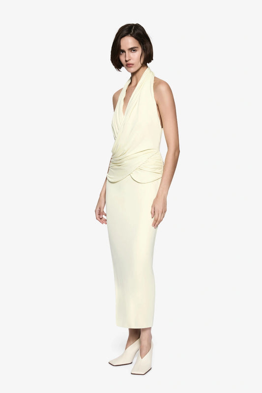 The Cabana Cupro Dress by MISHA, a lemon midi with halter neckline and soft hip drape. Perfect for weddings or refined summer events.
