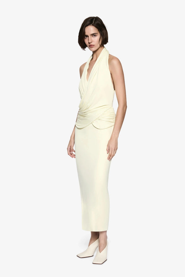 The Cabana Cupro Dress by MISHA, a lemon midi with halter neckline and soft hip drape. Perfect for weddings or refined summer events.