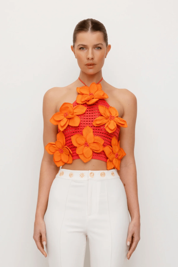 La Monada Knit Top Coral by The Wolf Gang, a bold and trendy piece with asymmetric neckline and cut-outs, crafted from soft ribbed knit, perfect for elevated, fashion-forward looks.