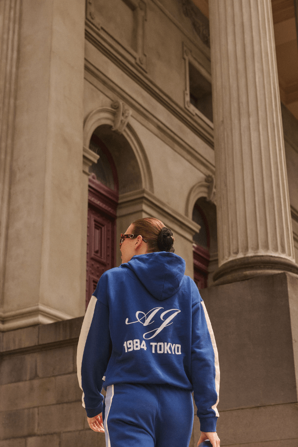 1984 Hoodie Estate Blue by Araminta James, soft cotton brushed fleece with contrast trim and velvet graphic, relaxed fit perfect for casual cool days.