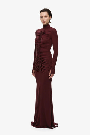 The Gathered Long Sleeve Maxi Dress by MISHA, ruched jersey maxi with mock neck and flared hem for sculpted evening styling.