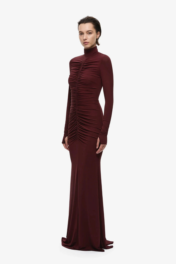The Gathered Long Sleeve Maxi Dress by MISHA, ruched jersey maxi with mock neck and flared hem for sculpted evening styling.