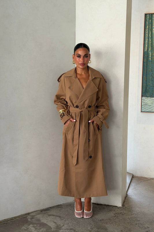 Trench Coat Tan by Sneaky Link – A timeless oversized coat in rich tan polyester, featuring classic details and subtle snake embroidery. Perfect for stylish transitional days.