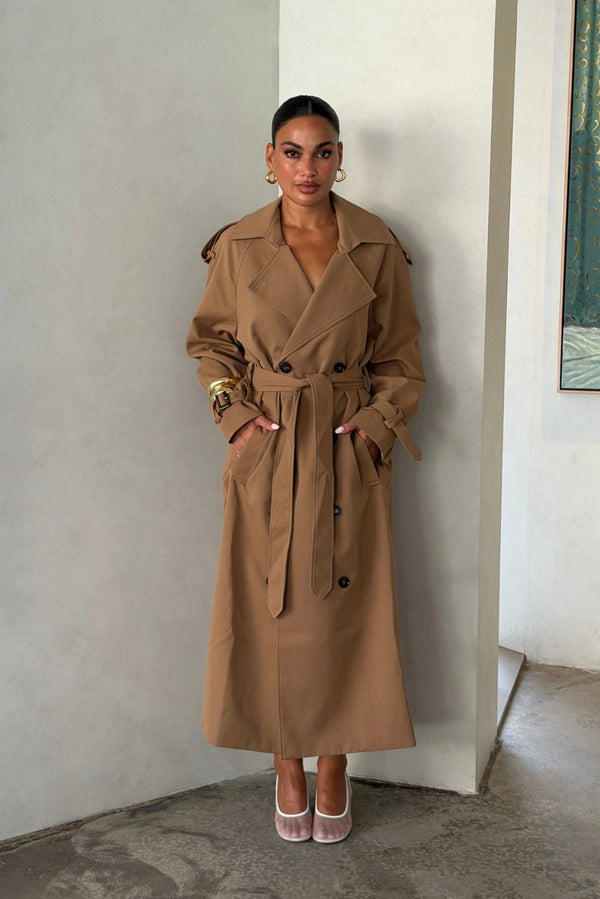 Trench Coat Tan by Sneaky Link – A timeless oversized coat in rich tan polyester, featuring classic details and subtle snake embroidery. Perfect for stylish transitional days.