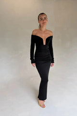 Black Haley off-shoulder midi dress with fitted bodice and flowy skirt, featuring short sleeves and a subtle slit.