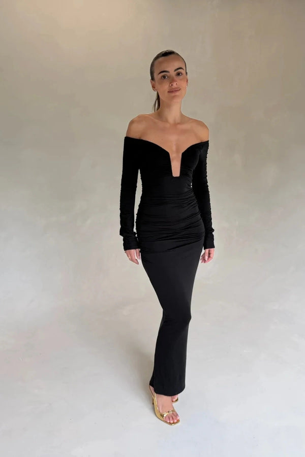 Black Haley off-shoulder midi dress with fitted bodice and flowy skirt, featuring short sleeves and a subtle slit.