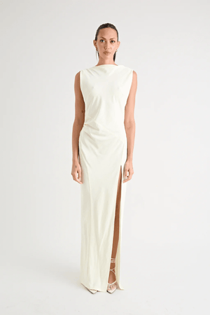 Matia Gown Butter by Pfeiffer – A timeless maxi with a boat neckline, low back, and adjustable strap. Perfect for elegant events and special occasions.
