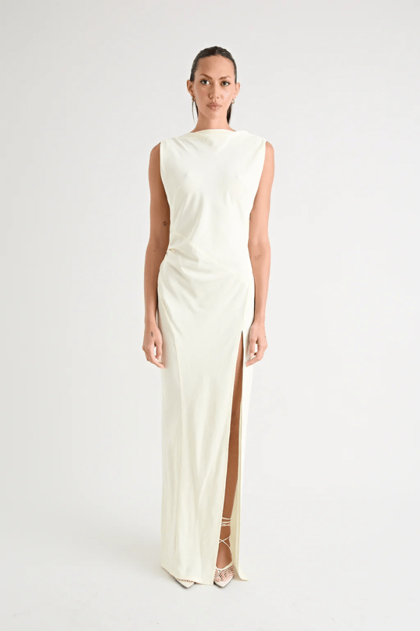 Matia Gown Butter by Pfeiffer – A timeless maxi with a boat neckline, low back, and adjustable strap. Perfect for elegant events and special occasions.