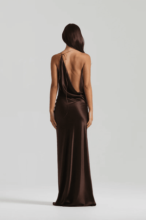 Gabi Gown Espresso by Natalie Rolt – A sleek, asymmetrical silk gown with dramatic open back and adjustable ties, perfect for elegant evening occasions.