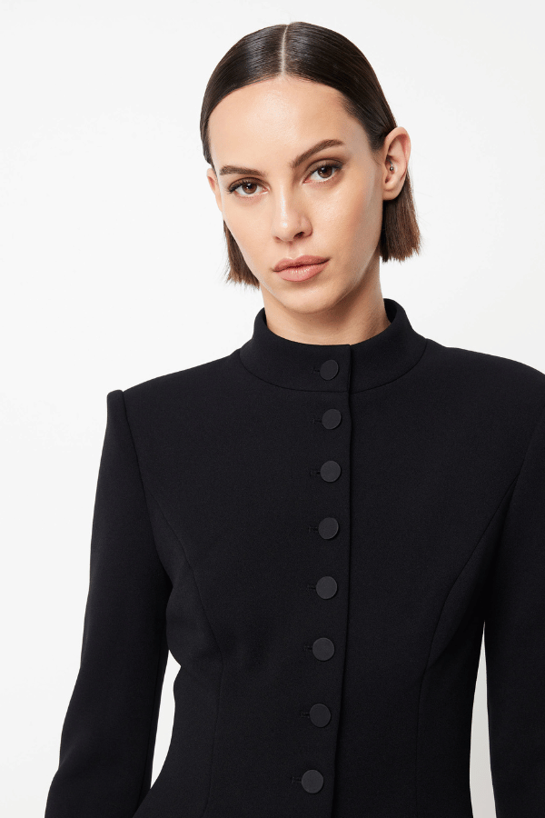 Network Mini Dress Black by Mossman – A sleek, structured LBD with padded shoulders, high neckline, and functional pockets, perfect for day-to-night chic.