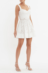 Nuvola Bustier Mini Dress Ivory by Rebecca Vallance – A chic broderie anglaise mini with sweetheart neckline, belted waist, and fitted bodice. Perfect for trendy daytime events or elegant summer parties.