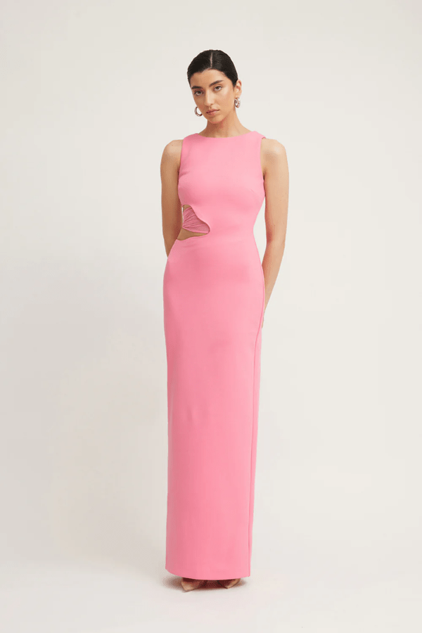 Valentina Dress Rouge Pink by Tojhà – A bold and sleek maxi with a boat neckline and unique waist cut-out, perfect for elegant evenings and special events.