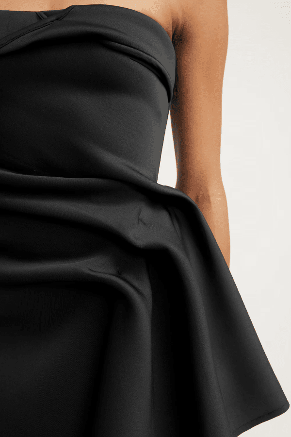 Nevie Dress Black by Tojhà – A trendy mini gown in light neoprene with waterfall drape and fixed fold details, perfect for chic, modern events.