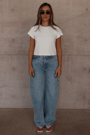 Claudia Baby Tee White by Sneaky Link – A relaxed, cropped tee crafted from a soft viscose-spandex blend for comfort and stretch. Perfect casual chic with short sleeves.