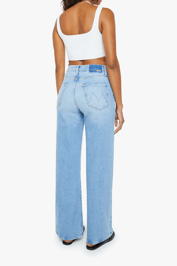 The Lasso Sneak Sow Surreal by MOTHER, trendy super high-rise wide-leg jeans with a light blue wash, whiskering, and fading. Perfect for a vintage-inspired look with a clean hem and structured fit.