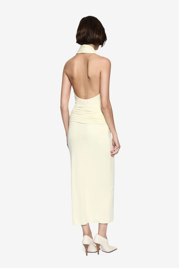 The Cabana Cupro Dress by MISHA, a lemon midi with halter neckline and soft hip drape. Perfect for weddings or refined summer events.