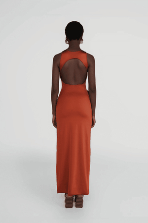 Tirso Terracotta by Maygel Coronel – Long dress with round neck, open back, ruched sash, and 3D flowers for elegant look.