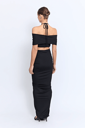 Angello Maxi Dress Black by Pfeiffer – A sleek off-shoulder maxi with cut-outs, front ruching, and an open back, perfect for formal evenings, special events, or statement celebrations.