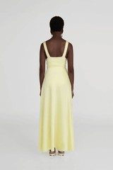 Orinoco Lime by Maygel Coronel – Maxi dress with deep V-neck, ruched bodice, 3D flowers, wide straps, and flowing skirt.