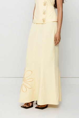 Inka Maxi Skirt Butter by The Wolf Gang, a flared godet midi with custom embroidery. Perfect for standout sets or sunny solo moments.