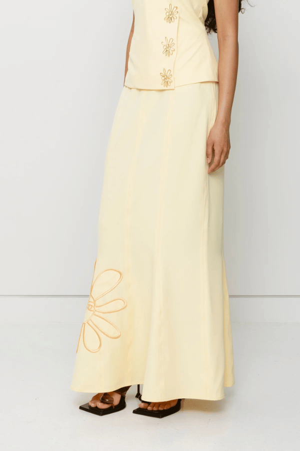 Inka Maxi Skirt Butter by The Wolf Gang, a flared godet midi with custom embroidery. Perfect for standout sets or sunny solo moments.