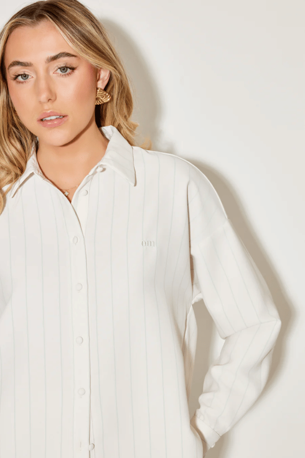 Ultimate Muse Pin Stripe Shirt Oat by Odd Muse — Classic pinstripe button-down with relaxed fit, breathable fabric, and OM embroidery for versatile, polished style.